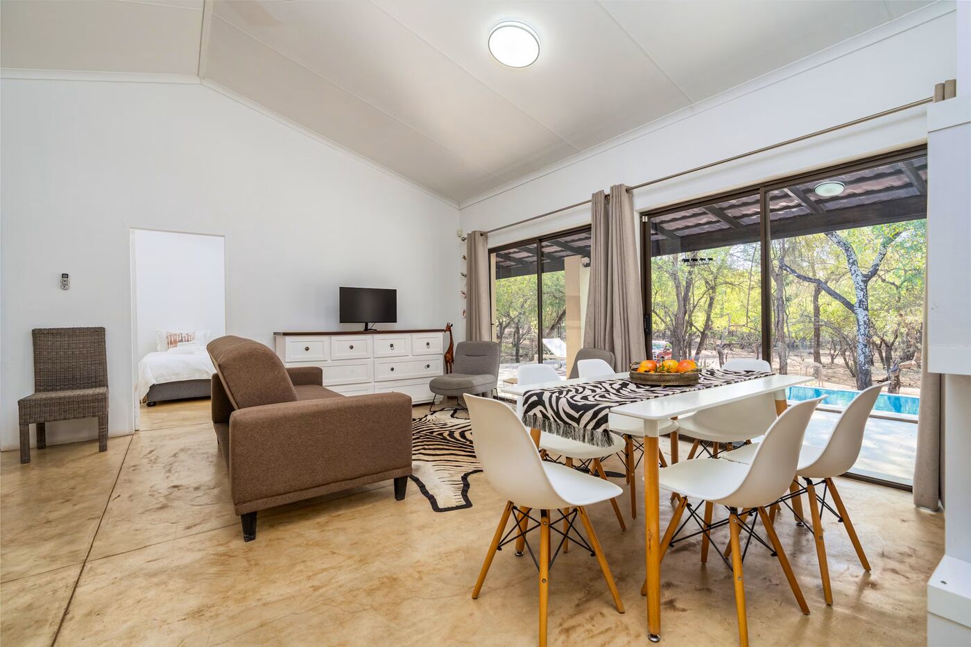 Open-plan living and dining area with pool view